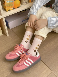 Gros plan de chaussettes roses avec broderies d'animaux et baskets en daim rose