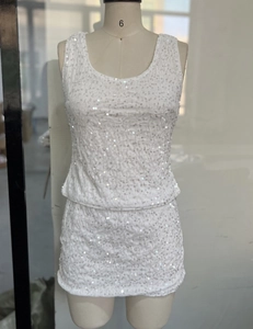 Close-up of white sequin texture on two-piece party set with vest and mini skirt