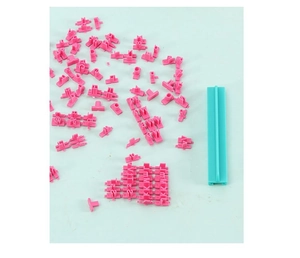 Pink alphabet and number cookie stamps with a cyan plastic handle tool for DIY baking