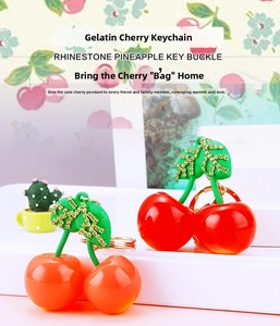 Detail of jelly resin cherry keychain featuring rhinestone leaves and gold metal ring