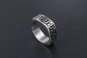 Macro view of silver titanium steel ring featuring black Greek key pattern and brushed finish