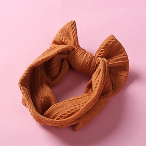 Detailed cable knit texture of caramel brown baby headband with large soft bow