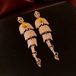 Vue détaillée des boucles d'oreilles vintage en or avec perles et pierres jaunes