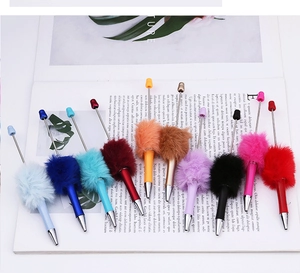 Flat lay of creative colorful plush beaded pens in ten vibrant colors on a magazine