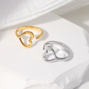 Detailed close-up of gold and silver open heart rings on a minimalist stone base