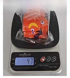 Detail showing the 47g weight of orange Halloween ribbon with spider web and bat prints