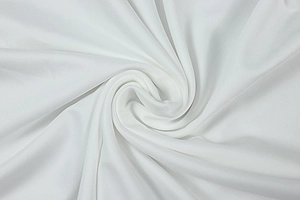 Macro du tissu blanc plissé montrant la texture détaillée du sergé et le drapé du matériau