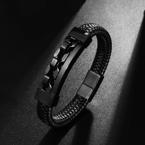 Detail of black braided leather bracelet with metal chain plate and magnetic buckle