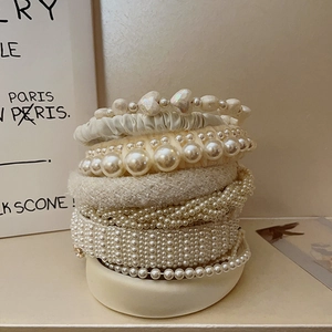 Detailed stack of French vintage fabric headbands featuring assorted pearls and hearts