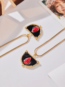 Détail de pendentifs éventail dorés à l'or 18k avec émail noir et pierre rouge goutte