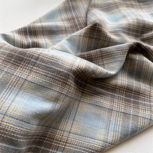 Detailed macro view showing the soft texture and weave of the plaid cashmere-like scarf