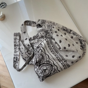 Detail shot of boho paisley print linen tote bag with textured weave fabric and wide strap