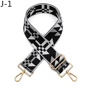 Detail of adjustable woven bag strap with black and grey geometric patterns and gold buckle