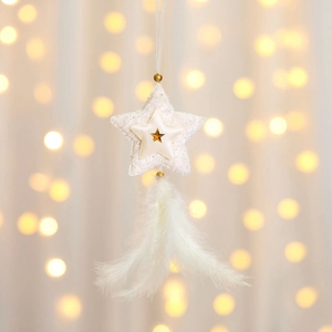Close-up of white fabric star ornament with gold details and soft hanging feathers