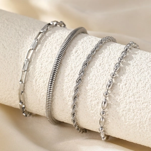 Set of four silver chain bracelets including paperclip and snake links on a display stand