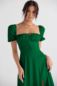 Detail of emerald green floral maxi dress with puff sleeves, lace-up front and leg slit