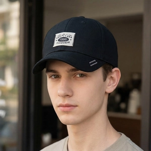 Classic black cotton baseball cap with graphic patch and embroidery on male model