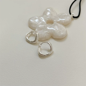 Vue détaillée de boucles d'oreilles créoles irrégulières en argent 925 style lave fond clair