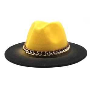 Detail of felt fedora hat featuring yellow crown, black brim and gold chain leather band