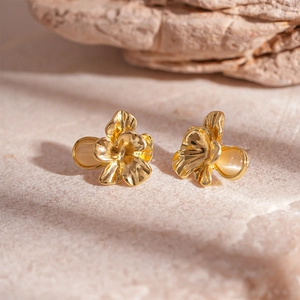Französische Vintage-Gold-Ohrstecker mit Blumen aus Kunstharz auf Steinhintergrund