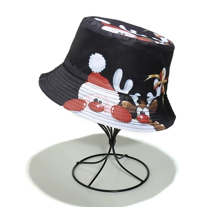 Close-up of black Christmas bucket hat featuring colorful Santa and reindeer cartoon prints