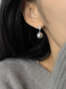 Detail of silver drop earrings with shimmering zircon pave and grey lustrous pearl