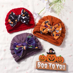 Set of three Halloween baby knit hats with large bows and festive pumpkin spider patterns