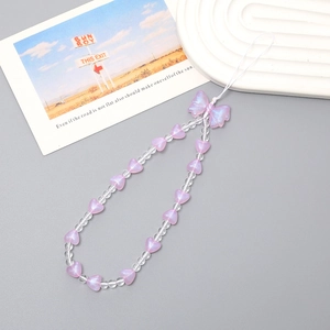 Close-up of pink bow and heart beaded phone strap with iridescent beads on a white tray