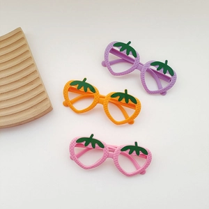Detailed view of three strawberry-shaped kids eyeglass frames in purple, orange, and pink colors