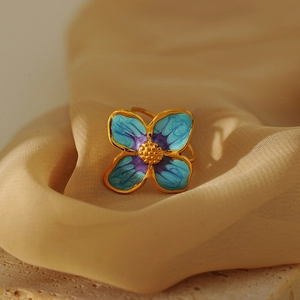 Elegant gold-plated stainless steel ring with blue-purple enamel flower on silk background
