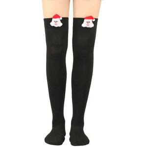 Detail of black over-the-knee Christmas socks with a 3D plush Santa Claus at the cuff