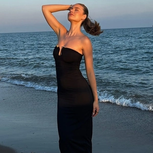 Close-up of black U-neck strapless bodycon dress with ruching detail on beach