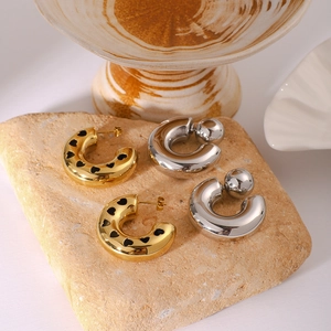 Vintage hollow 18K gold stainless steel heart hoop earrings on a rustic stone base