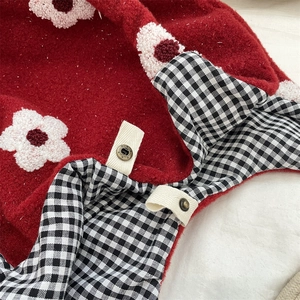 Close-up of red sherpa tote with floral embroidery and black-and-white gingham lining