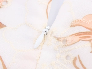 Dettaglio di cerniera invisibile e ricamo su un abito boho floreale con cuciture fini