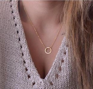 Close-up of a double-layered gold necklace featuring a minimalist hollow circular pendant