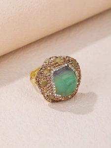 Detalle macro de anillo de fluorita verde con halo doble de cristal y baño de oro elegante