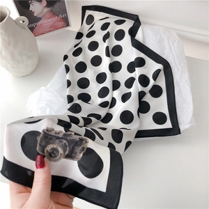 Detail of white silk scarf with black polka dots and vintage camera print on the corner