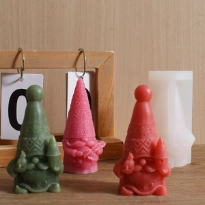 Detailed view of gnome silicone molds with green, pink and red Christmas candle crafts