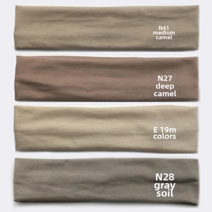Flat lay of four elastic cotton sports headbands in camel, beige and grey earth tones