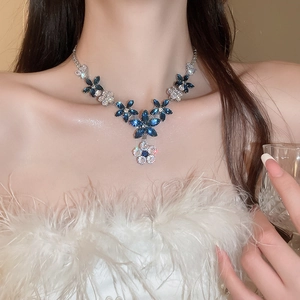 Detail of blue and white zircon flower necklace on model showing layered crystal design