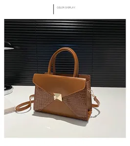 Detail of brown crocodile pattern patchwork tote with golden metal triangle buckle closure