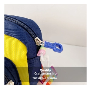 Close-up detail of durable blue and yellow canvas crossbody bag with rainbow strap and zipper