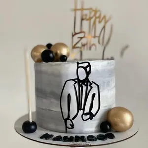Detail of custom marble-patterned cake with acrylic suit figure and golden birthday topper