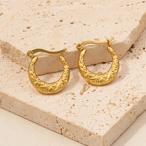 Detail shot of vintage 18K gold plated hoop earrings with intricate scroll embossing