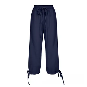 Close-up of deep blue cotton linen pants featuring drawstring waist and tied ankle cuffs