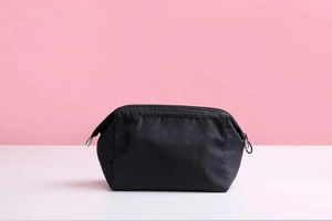 Close-up of black nylon waterproof makeup bag with smooth zipper and side pull tab detail