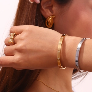 Close-up of elegant gold bow ring and star-patterned bracelets on a female model