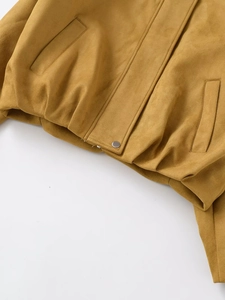 Detailed macro view of suede bomber jacket hem with silver metal button and fine stitching