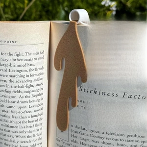 Detailed view of creative spilled coffee bookmark with brown fluid shape tucked in a book